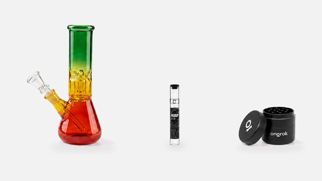 Bong de vidrio rasta de 20 cm, pipa GRAV Taster de vidrio de borosilicato y grinder ONGROK de aluminio negro de cuatro piezas con la tapa recostada, alineados a escala real sobre fondo gris claro.