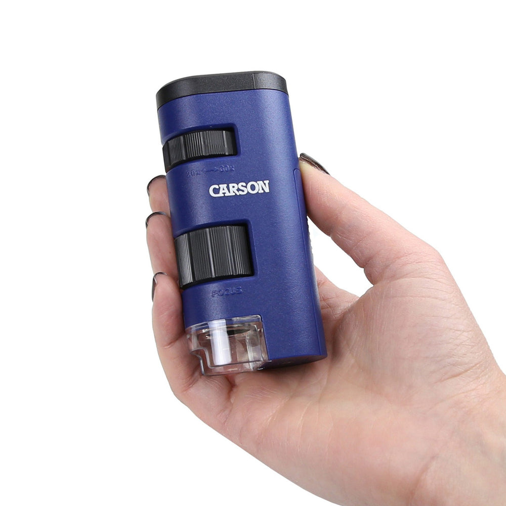 Microscopio Carson MM-450 en la mano mostrando tamaño portátil