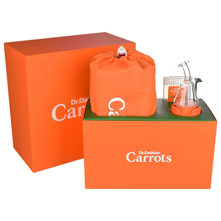 Caja naranja del Dr. Dabber Boost EVO Carrots Edition abierta, con la bolsa de viaje Carrots, el vidrio sobre su adaptador, los hisopos y la herramienta de carga verde