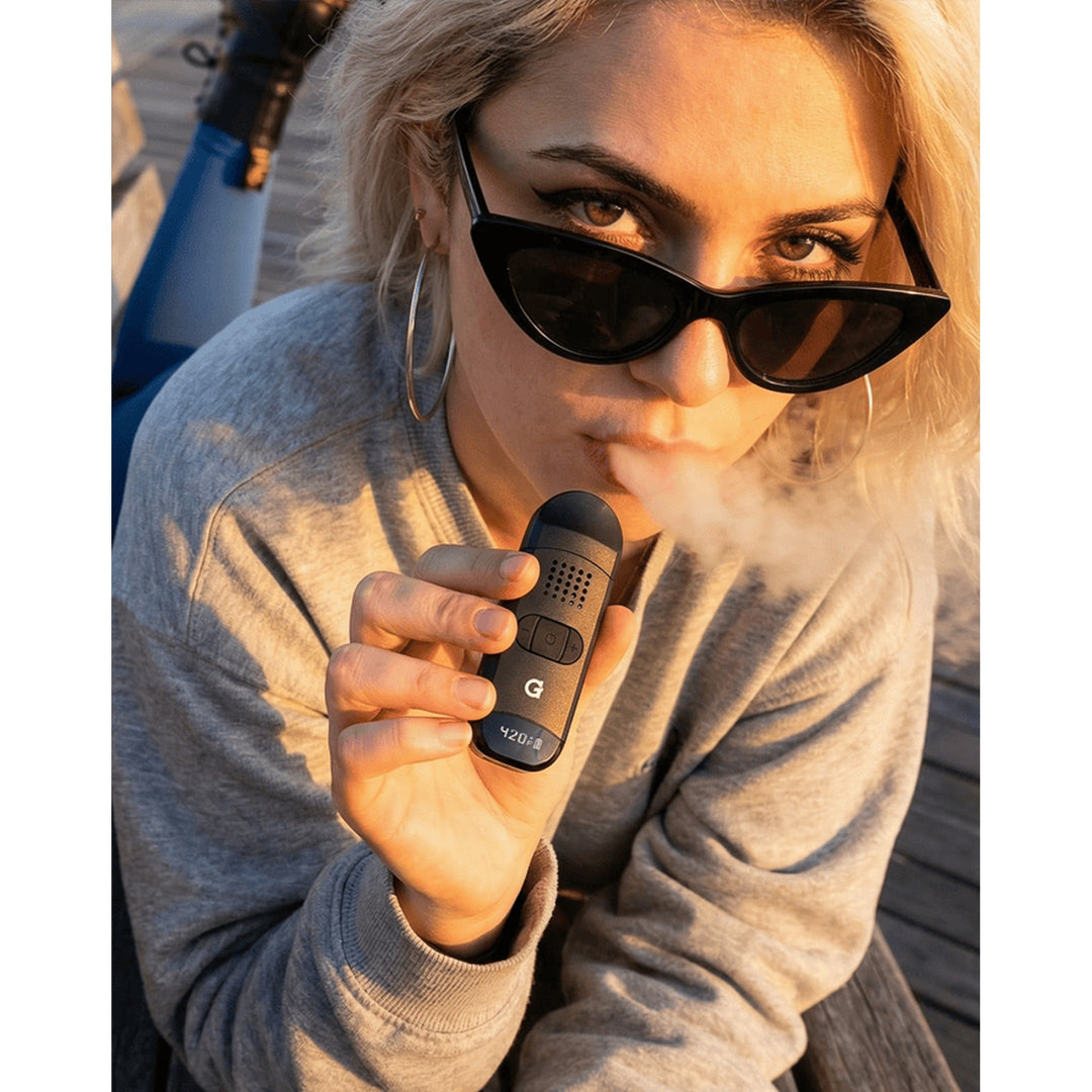 Mujer usando el vaporizador G Pen Dash II
