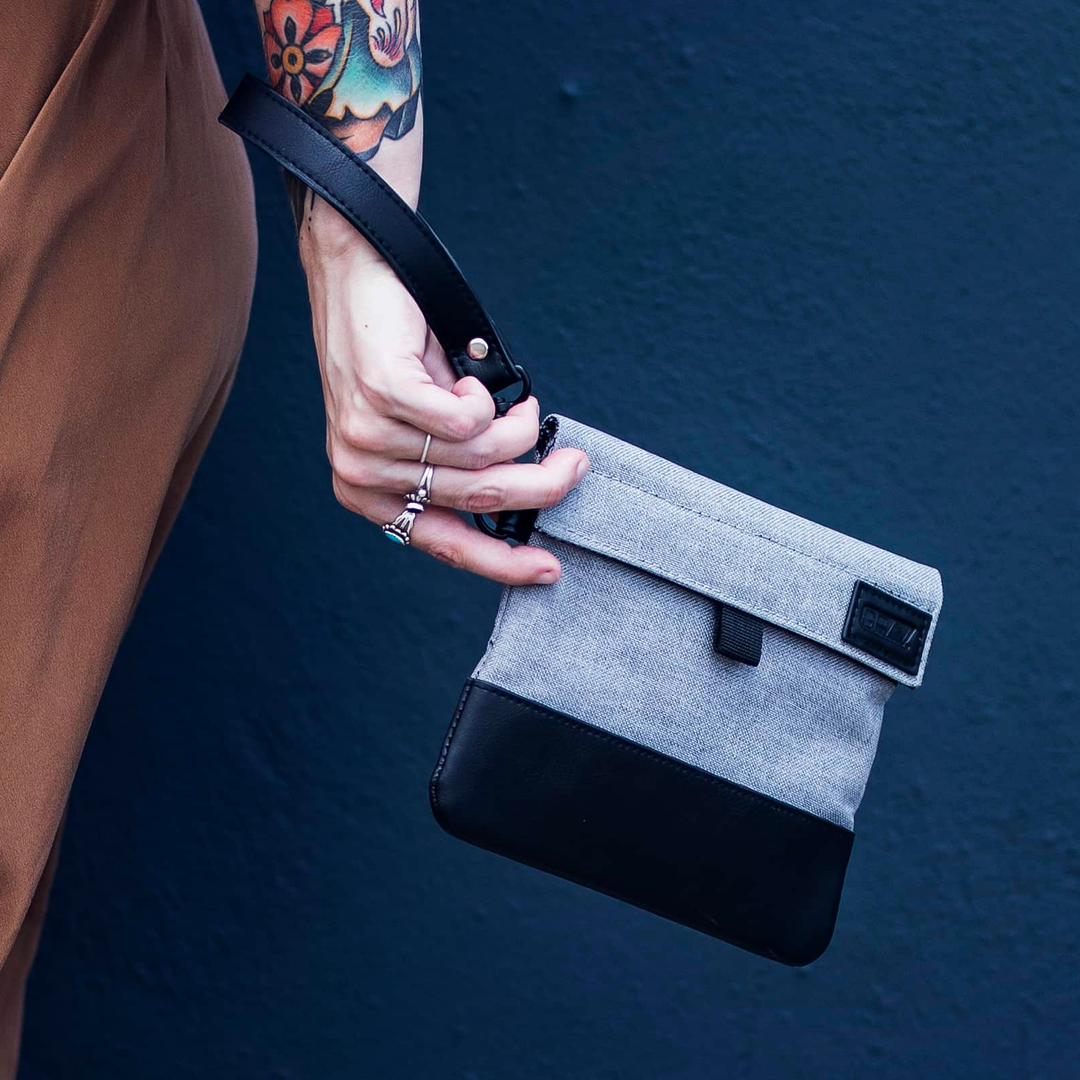 GRAV Smell-Proof Pouch negro colgado de la mano con su correa de clip