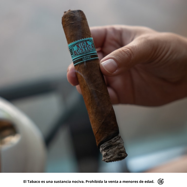 Tabaco premium Nica Rustica Adobe Gordo sostenido en mano listo para fumar.